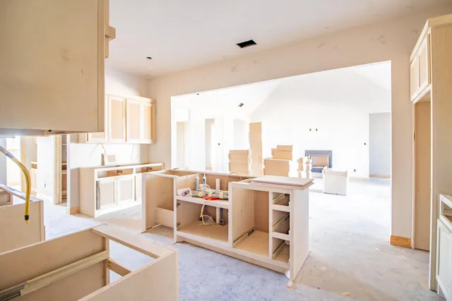a living room with stainless steel appliances kitchen island granite countertop a sink and cabinets