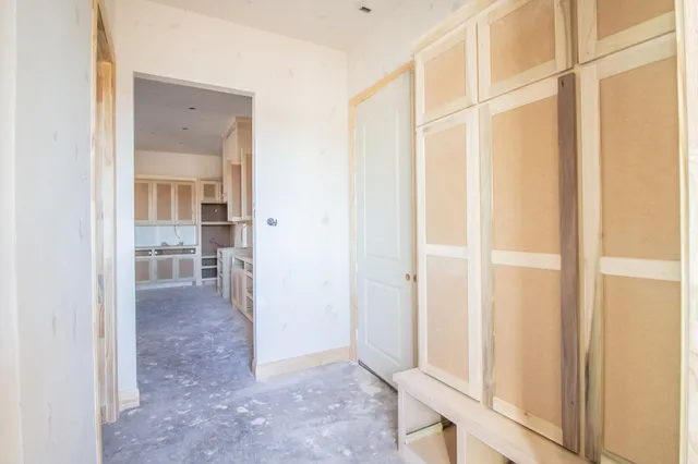a view of a hallway with wooden floor and entryway