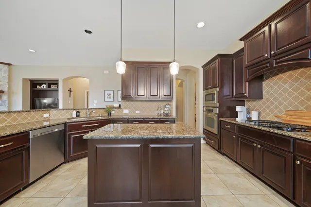 a kitchen with stainless steel appliances granite countertop a sink and stove