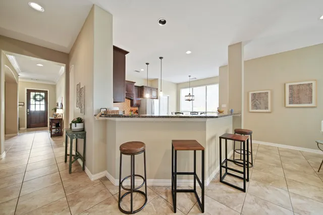 a dining hall with stainless steel appliances granite countertop a table and chairs