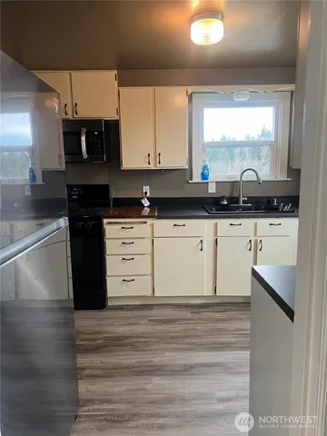 a kitchen with stainless steel appliances granite countertop a stove a sink and a microwave