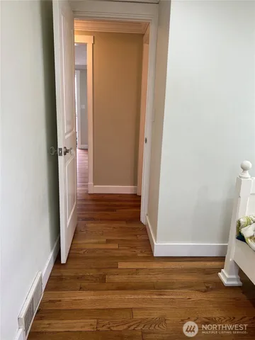 a view of a hallway with wooden floor and closet