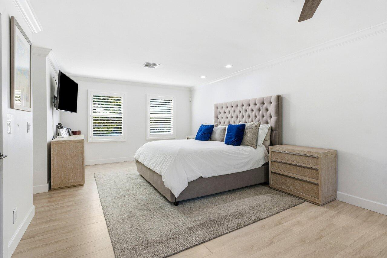 5696 Northwest 39th Avenue Boca Raton, FL 33496 - Photo 13 of 24 a bedroom with a large bed and a flat screen tv