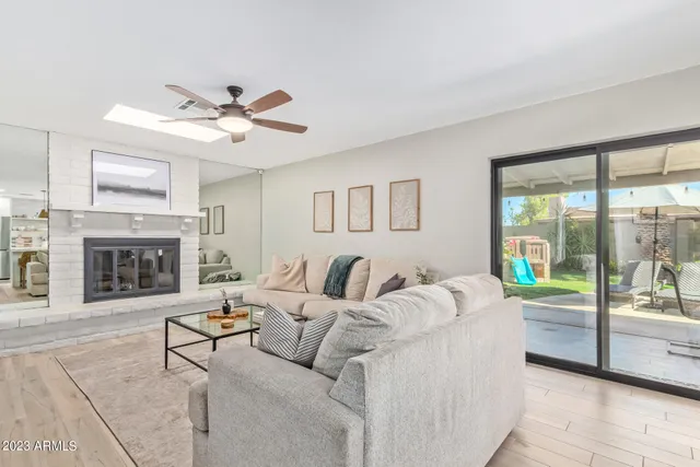 a living room with furniture a fireplace and a large window
