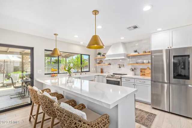 a kitchen with stainless steel appliances granite countertop a sink a stove and a refrigerator