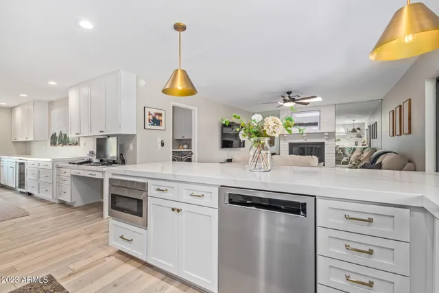 a kitchen with stainless steel appliances granite countertop a sink a stove and a wooden floors
