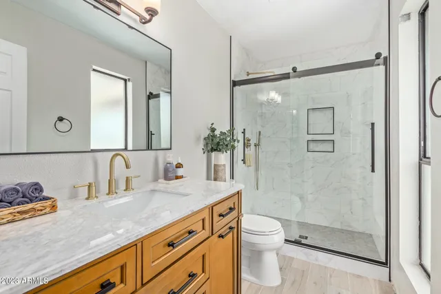 a bathroom with a granite countertop sink toilet and shower