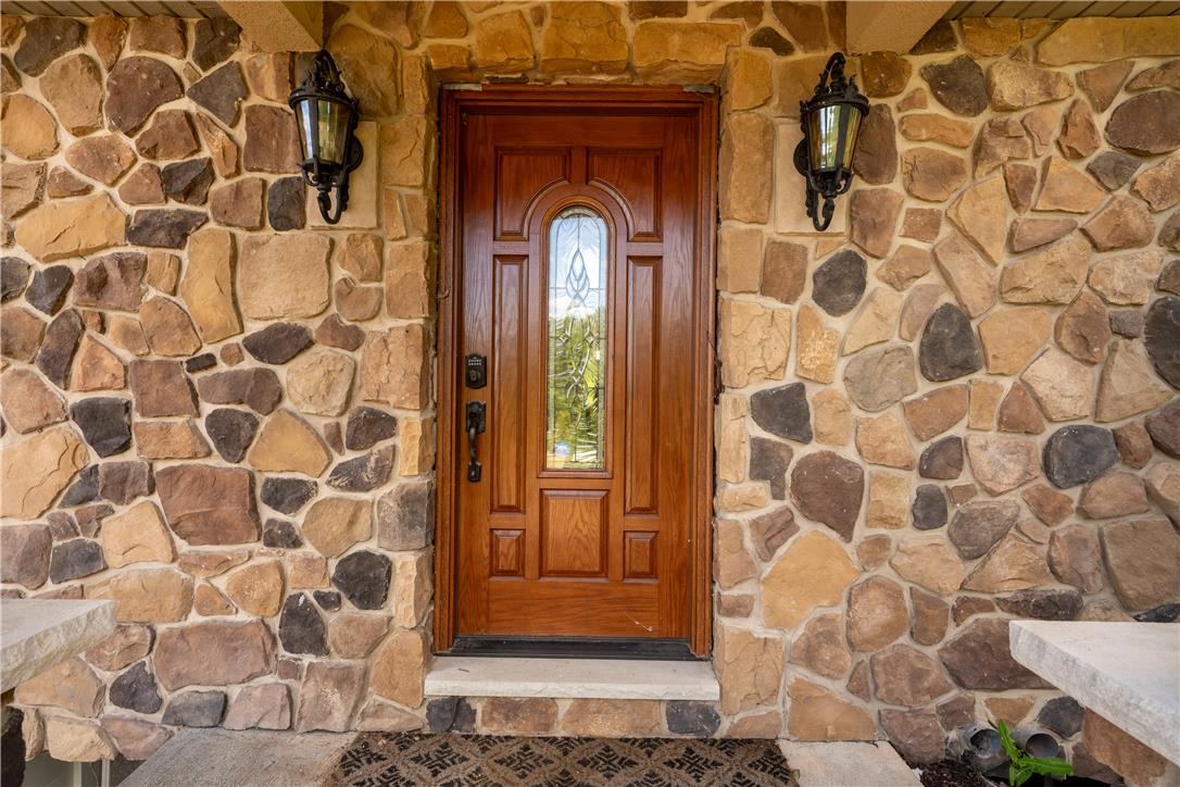 374 Packer Drive Weatherly, PA 18255 - Photo 4 of 30 A welcoming entry features a paneled wooden door with decorative glass, flanked by rustic stone veneer.
