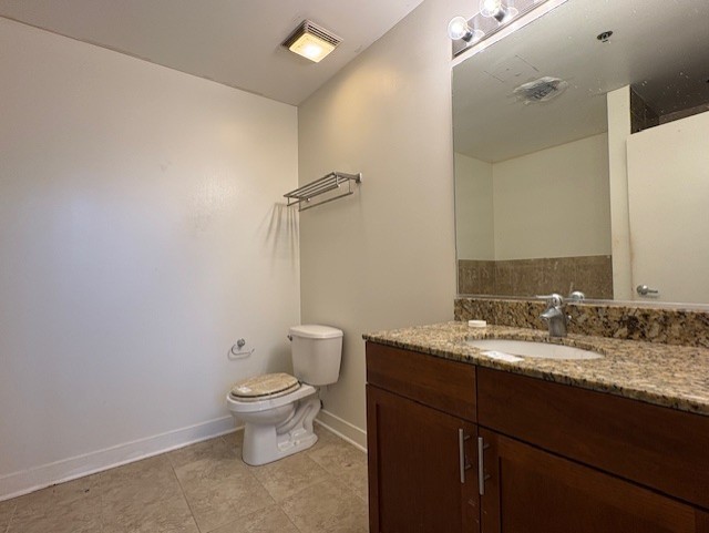 320 East 21st Street, Unit 405 Chicago, IL 60616 - Photo 13 of 15 a bathroom with a granite countertop sink a toilet and a mirror