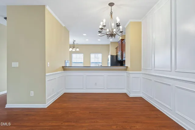 a view of an empty room with wooden floor fireplace and a window