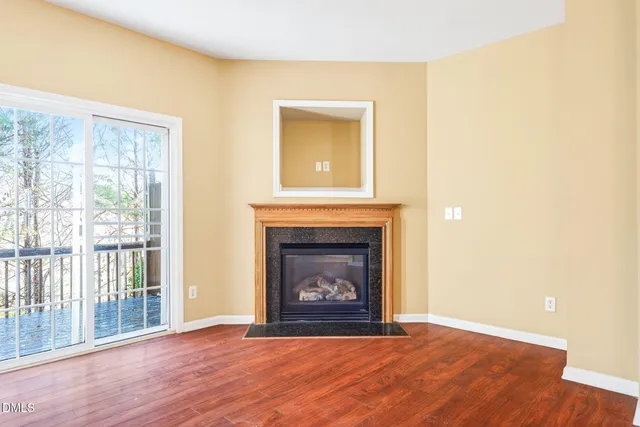 a view of an empty room with a window and a fireplace