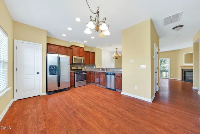 a kitchen with stainless steel appliances granite countertop a refrigerator and a stove top oven