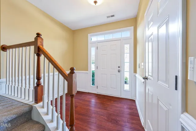 a view of a hallway with wooden floor and staircase
