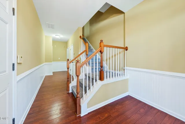 a view of a hallway with wooden floor and staircase