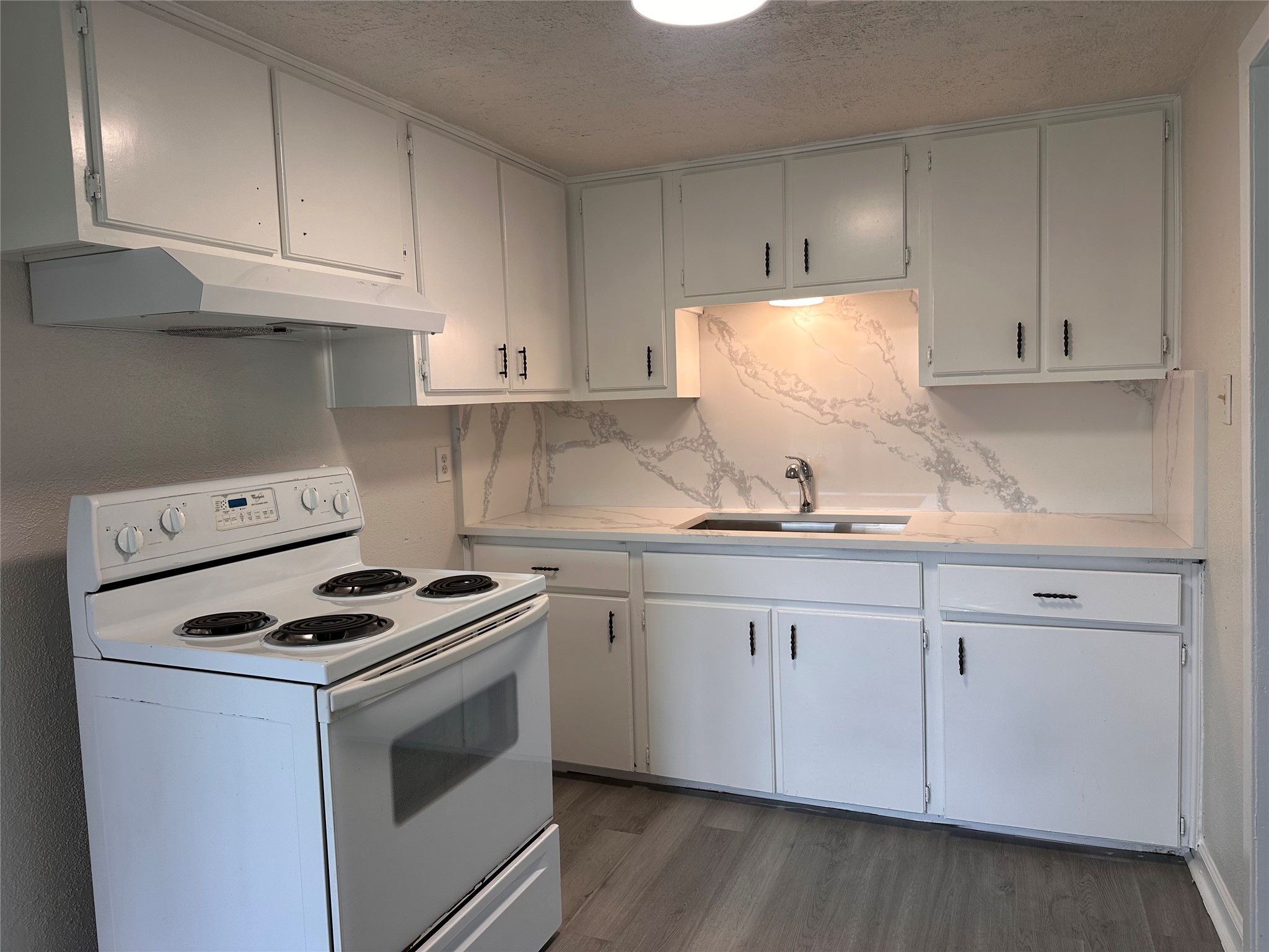 2516 Ivy Street Houston, TX 77026 - Photo 8 of 9 a kitchen with granite countertop white cabinets and white appliances