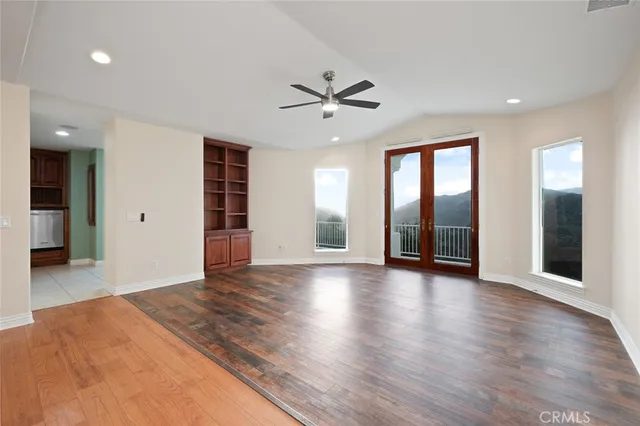 a view of a livingroom with a chandelier fan and windows