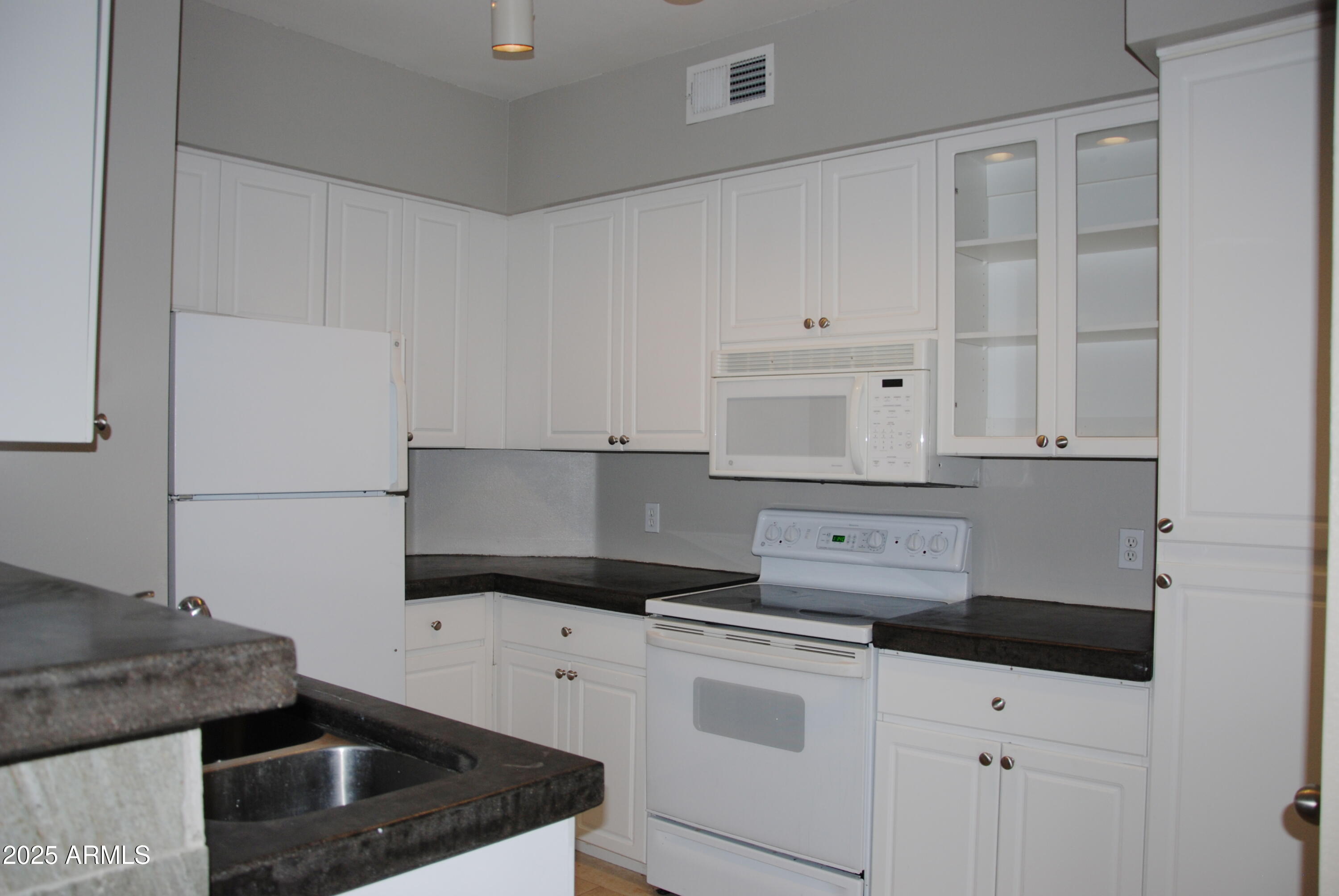 a kitchen with white cabinets and white appliances