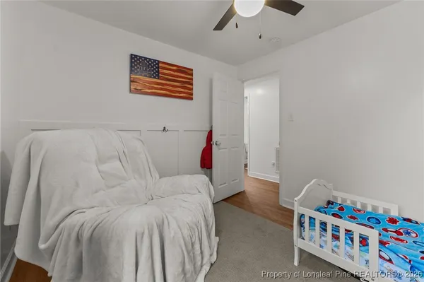 a bedroom with a bed and a lamp on the dresser