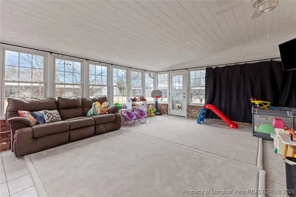 a living room with furniture a gym equipment and a flat screen tv