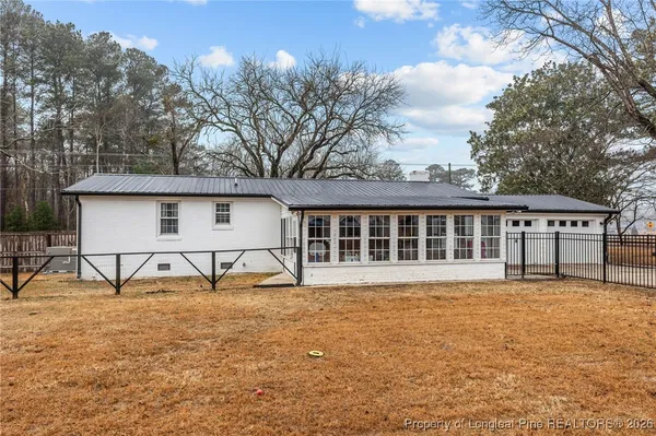 a view of house with backyard and trees