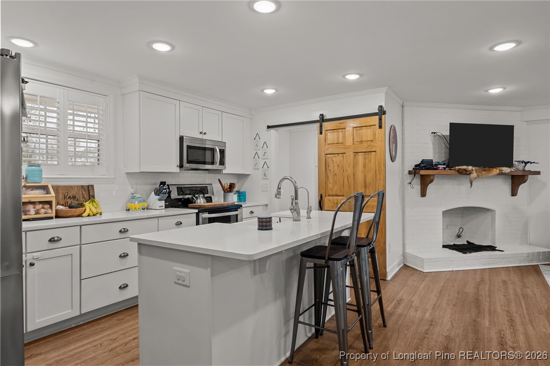 2060 Wade-Stedman Road Stedman, NC 28391 - Photo 6 of 41 a kitchen with a sink microwave cabinets and wooden floor