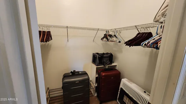 a view of walk in closet with clothes and shoes