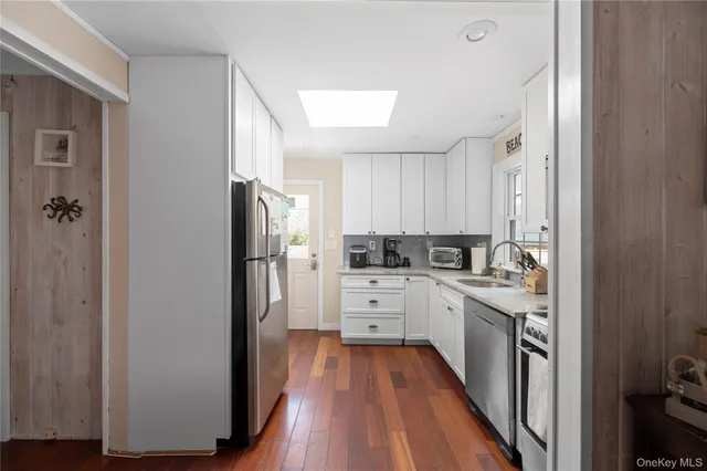 a kitchen with stainless steel appliances a stove top oven a refrigerator a dining table and chairs