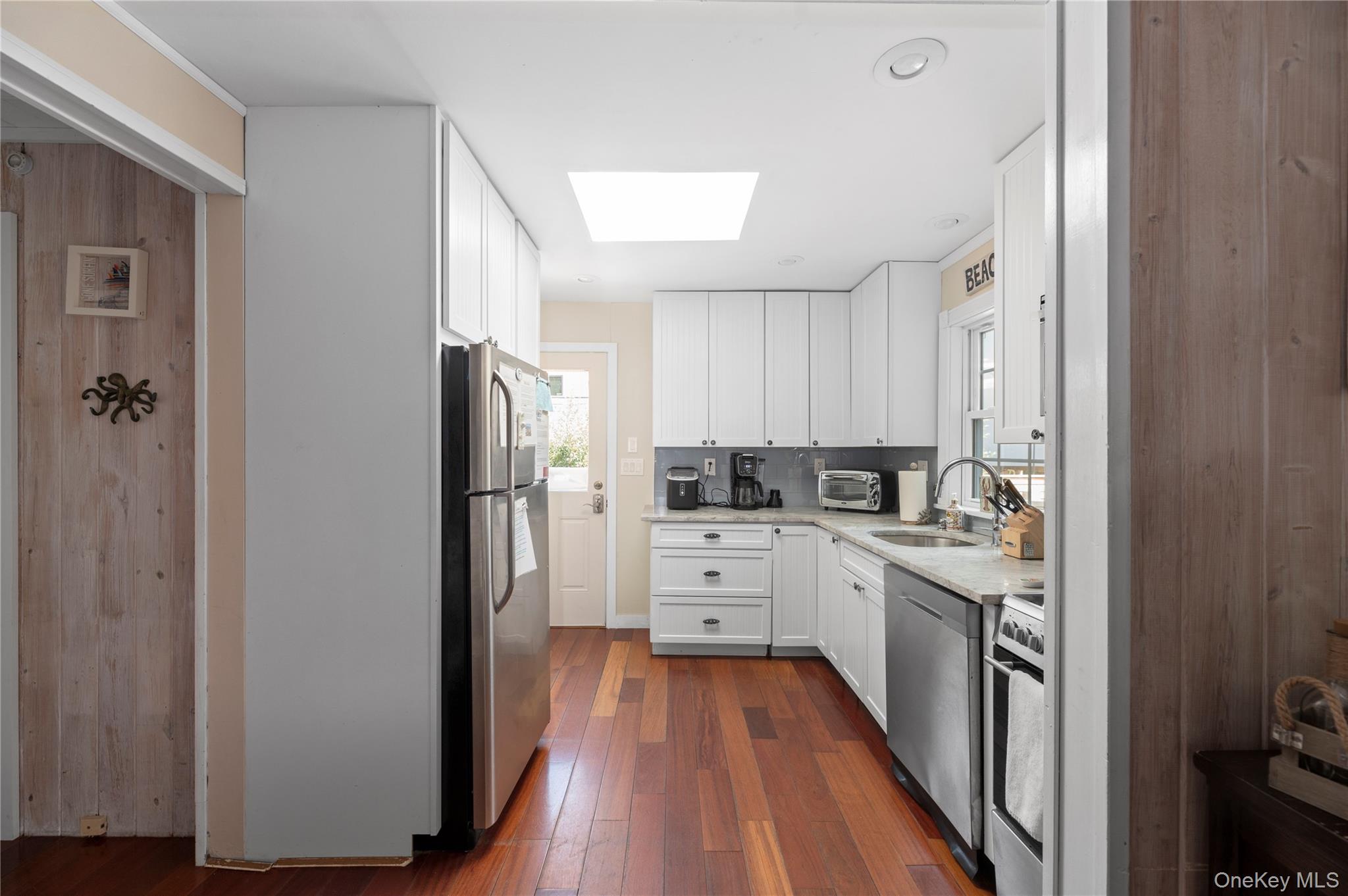 20 Seneca Walk Ocean Beach, NY 11770 - Photo 4 of 19 a kitchen with white cabinets and stainless steel appliances