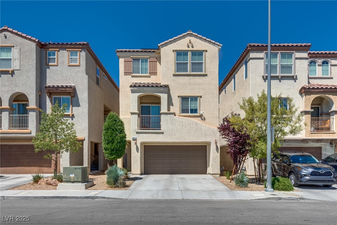 10519 Mann Street Las Vegas, NV 89141 - Photo 1 of 48 View of front facade featuring stucco siding, a garage, a tile roof, and concrete driveway