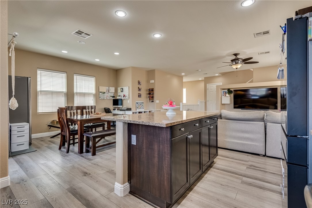 10519 Mann Street Las Vegas, NV 89141 - Photo 44 of 48 Kitchen featuring open floor plan, dark brown cabinetry, baseboards, ceiling fan, and light wood-style flooring