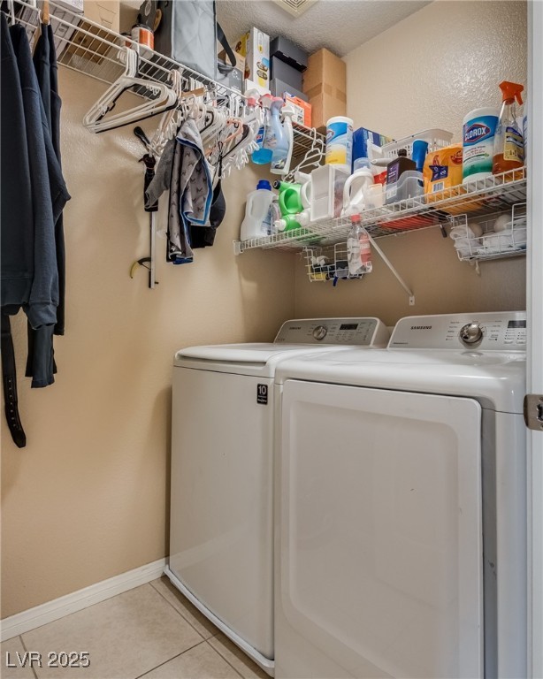 10519 Mann Street Las Vegas, NV 89141 - Photo 25 of 48 Clothes washing area featuring washing machine and dryer, light tile patterned flooring, and baseboards