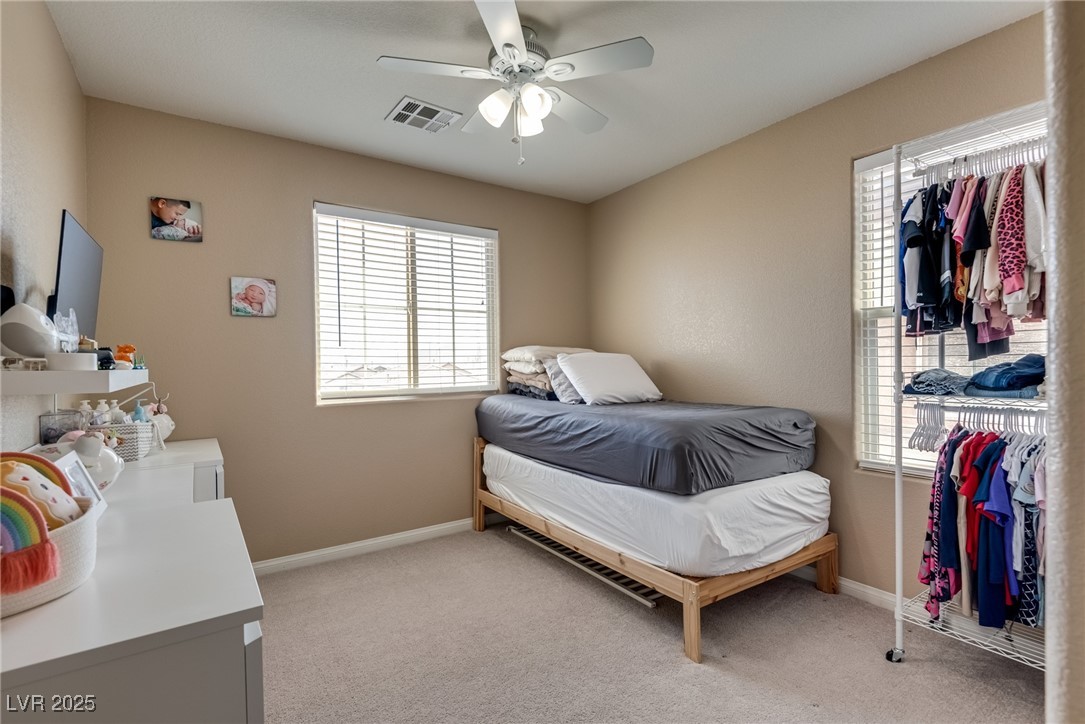 10519 Mann Street Las Vegas, NV 89141 - Photo 26 of 48 Bedroom with multiple windows, light colored carpet, and baseboards
