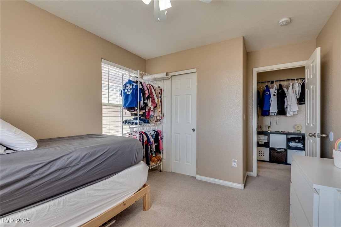 10519 Mann Street Las Vegas, NV 89141 - Photo 27 of 48 Bedroom featuring light colored carpet, baseboards, ceiling fan, and a closet