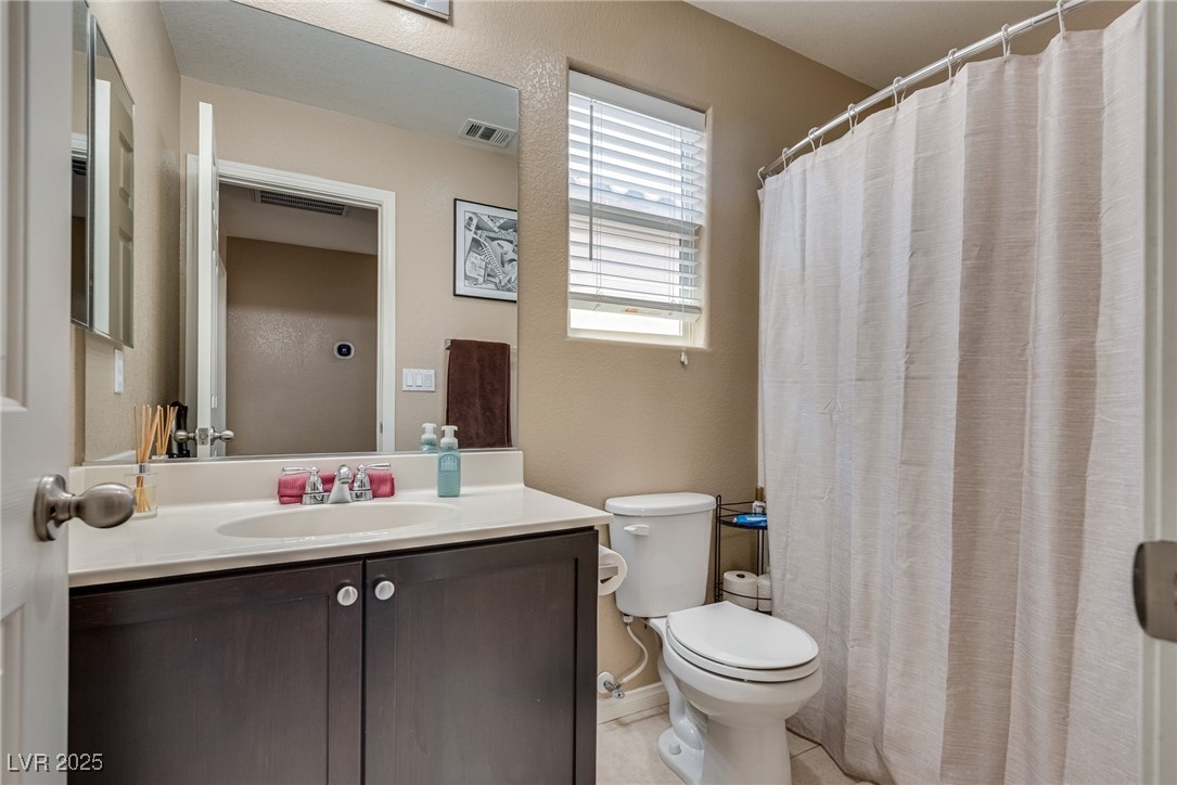10519 Mann Street Las Vegas, NV 89141 - Photo 28 of 48 Bathroom with toilet, vanity, curtained shower, and tile patterned floors
