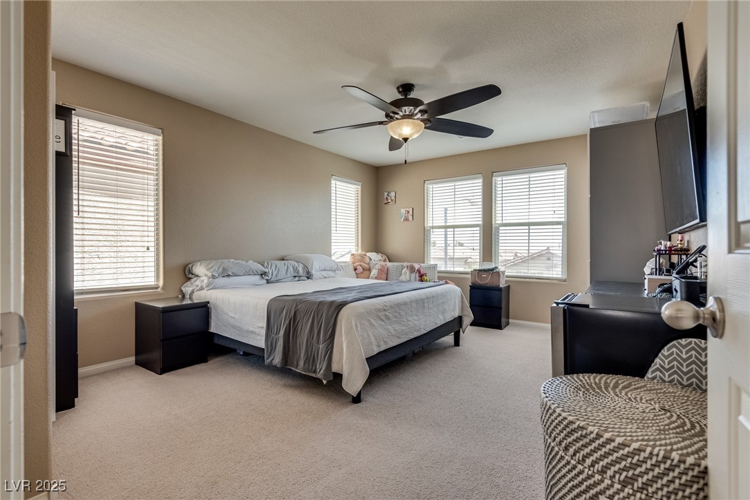10519 Mann Street Las Vegas, NV 89141 - Photo 29 of 48 Bedroom with light carpet, baseboards, and ceiling fan