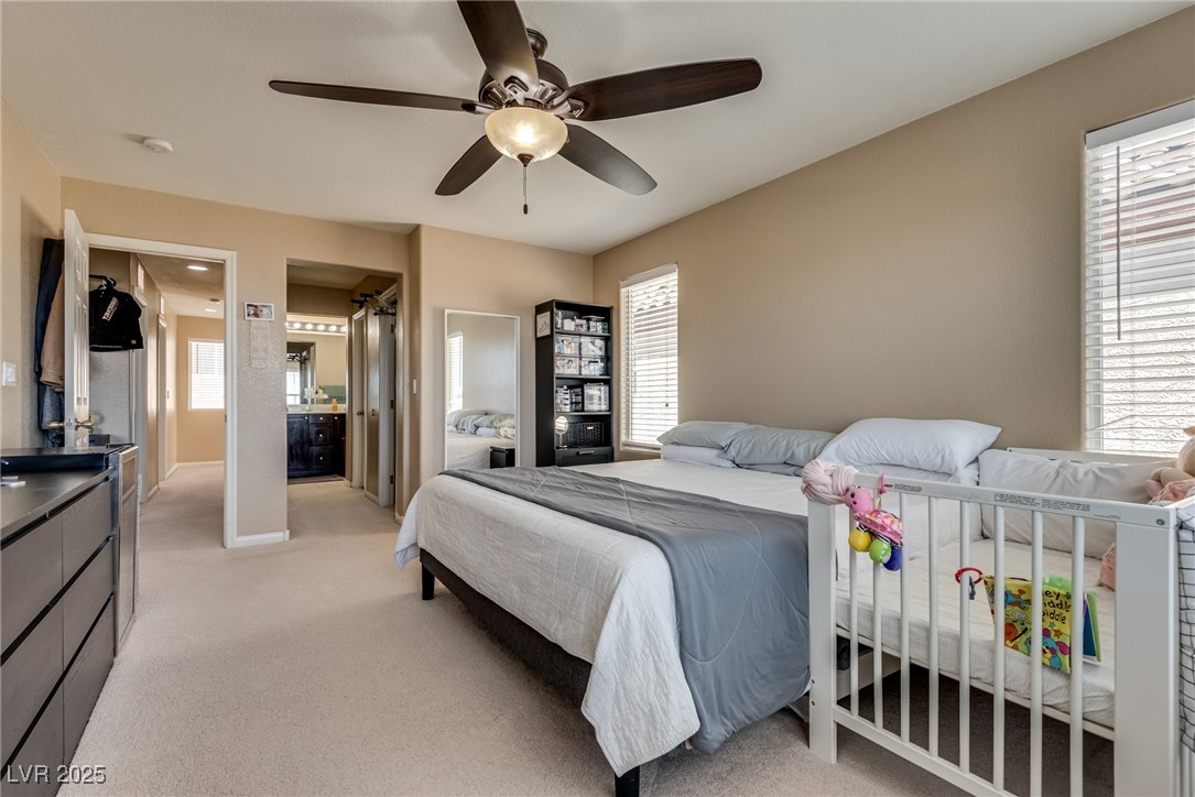 10519 Mann Street Las Vegas, NV 89141 - Photo 30 of 48 Bedroom with multiple windows, light colored carpet, and a ceiling fan