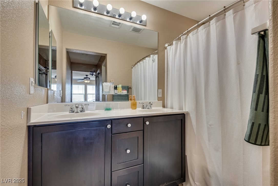 10519 Mann Street Las Vegas, NV 89141 - Photo 33 of 48 Bathroom with a textured wall and double vanity
