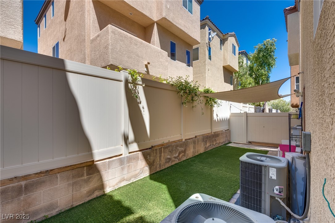 10519 Mann Street Las Vegas, NV 89141 - Photo 4 of 48 View of yard with central AC unit and fence