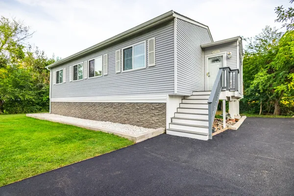 a front view of a house with a garden