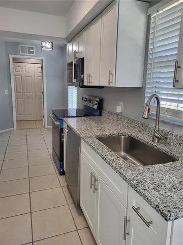 a kitchen with a sink cabinets and utility