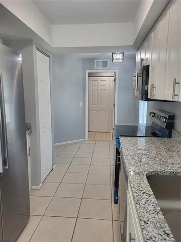 a kitchen with stainless steel appliances granite countertop a refrigerator and a sink