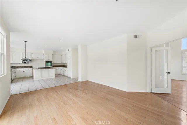 a view of a kitchen with kitchen island white cabinets and stainless steel appliances