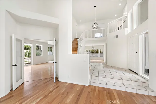 a view of a hallway with wooden floor and a kitchen