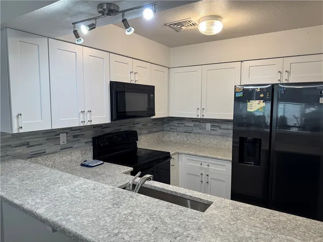 a kitchen with a sink and steel appliances