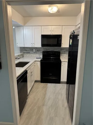 a kitchen with granite countertop cabinets stainless steel appliances and a counter space