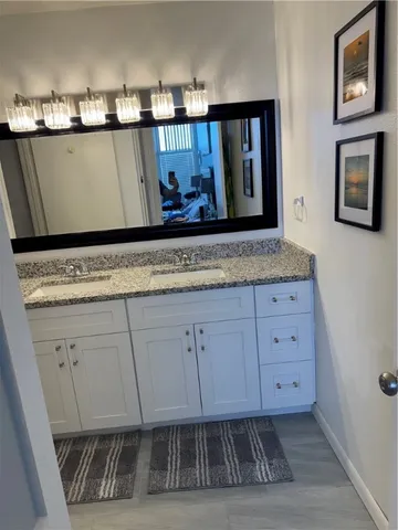 a bathroom with a granite countertop bathtub shower sink and toilet