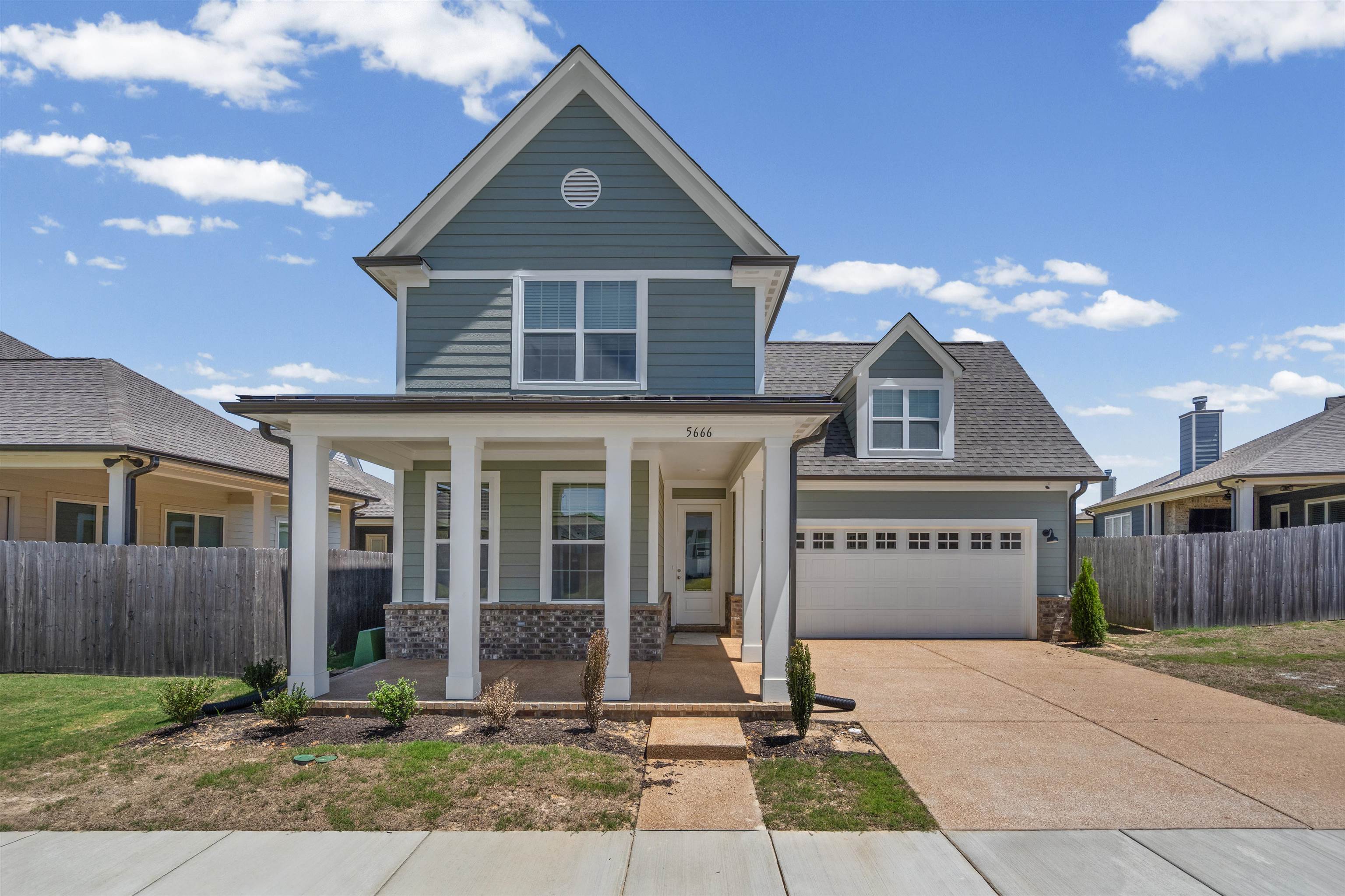 Modern craftsman-style exterior with blue siding and white trim