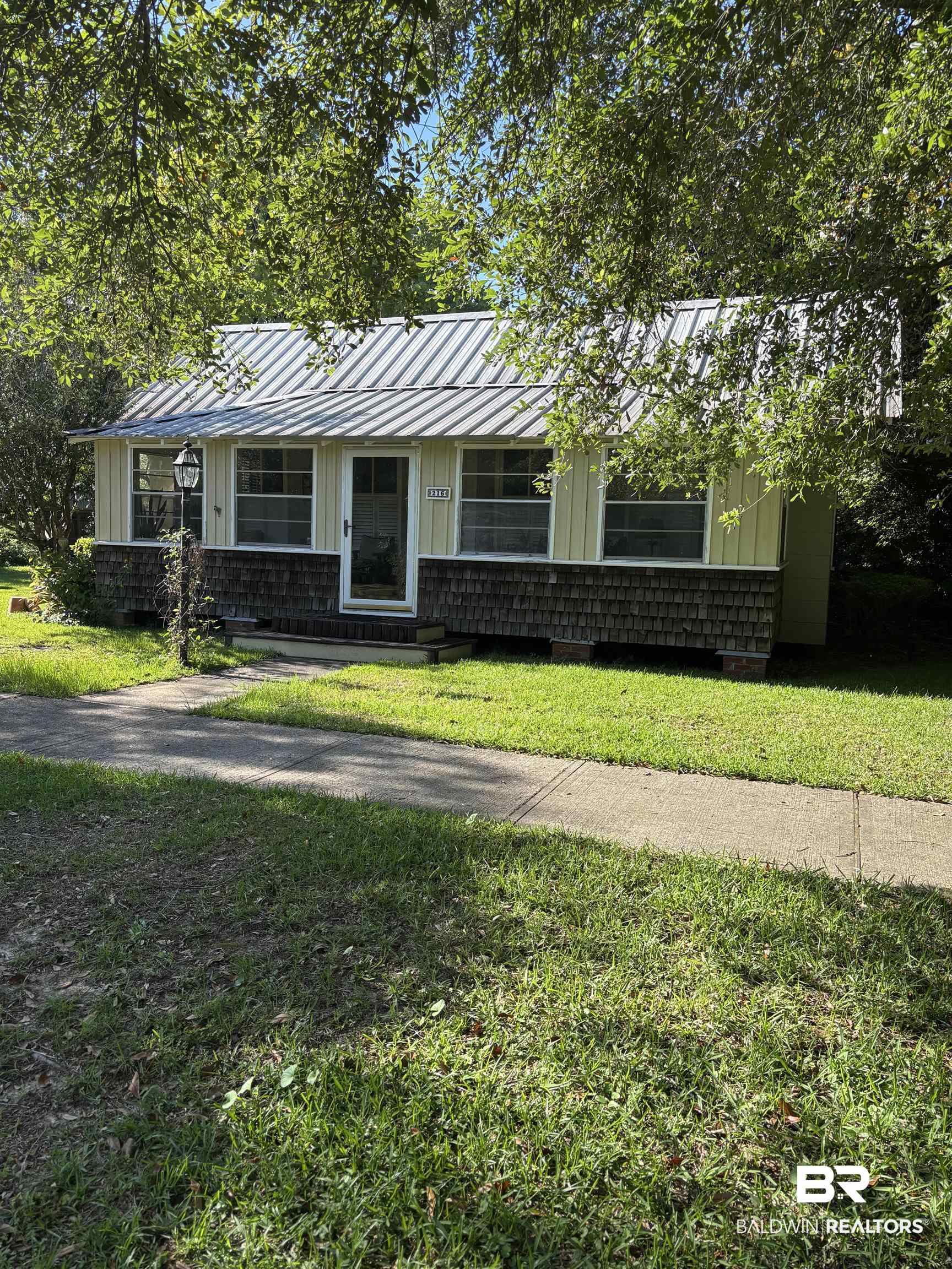 216 West Orange Avenue Foley, AL 36535 - Photo 3 of 37 View of front of property with a standing seam roof, a front lawn, metal roof, and board and batten siding