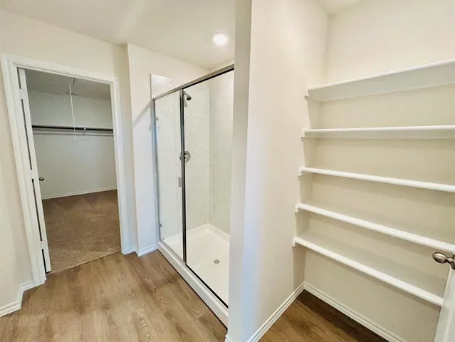 a view of walk in closet with empty racks