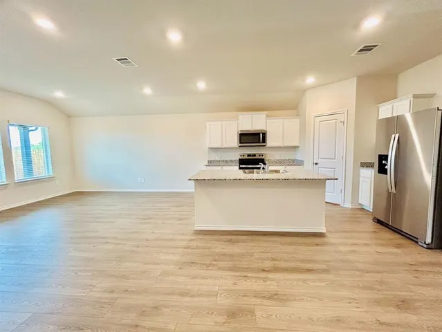 a kitchen with kitchen island a refrigerator sink and microwave